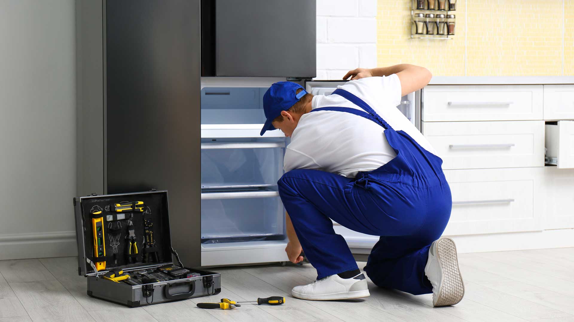 Technician repairing a refrigerator